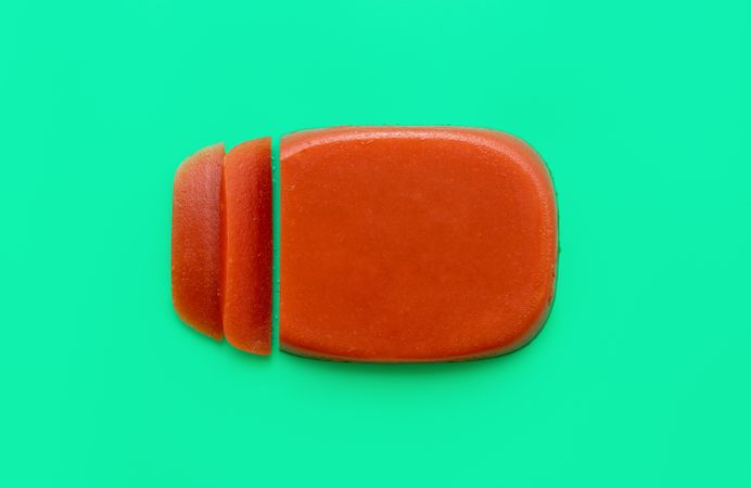 Sliced quince jelly for cheese plate on bright green background