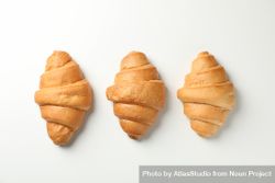 Top view of row of three croissants bEjol0