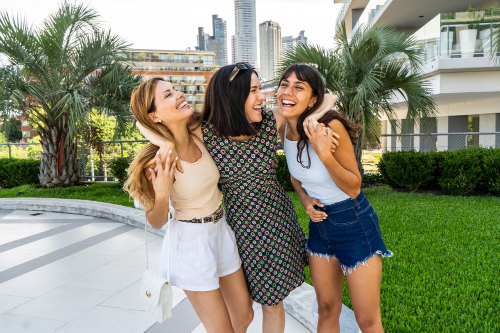 Portrait of three friends embracing together while laughing