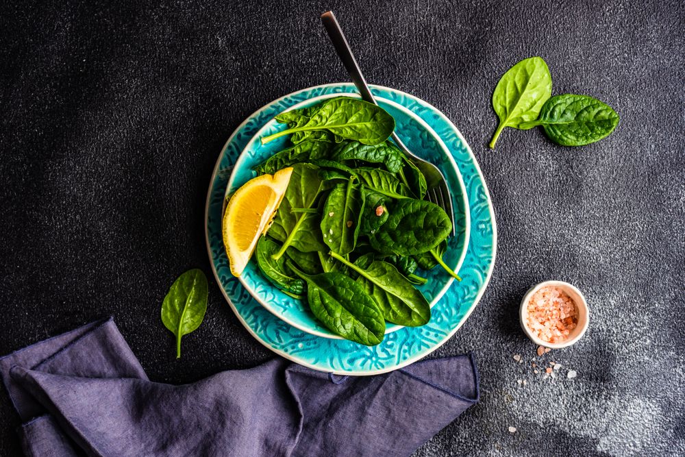Looking down at spinach salad with lemon slice
