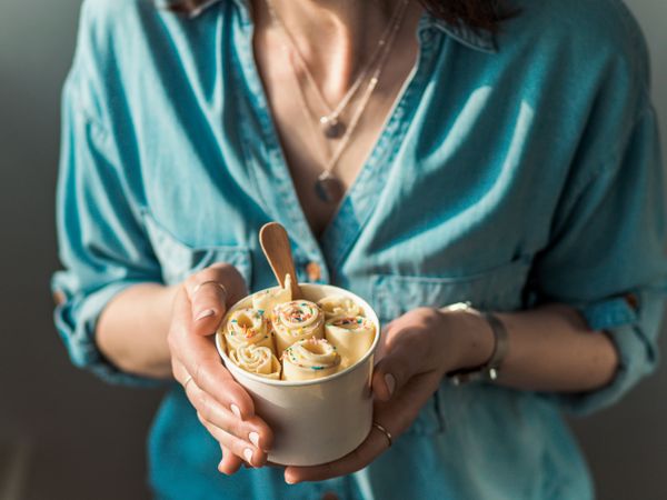Hand holding rolled ice cream in cone cup