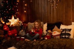 Little girl with teddy surrounded by christmas decoration