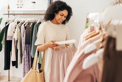 Woman looking at a quality of shorts in a clothing store