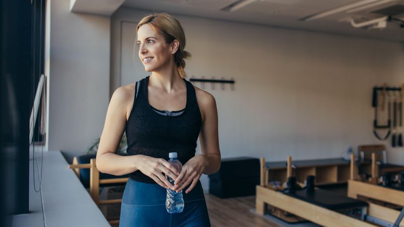 Woman relaxing after workout standing in a pilates gym