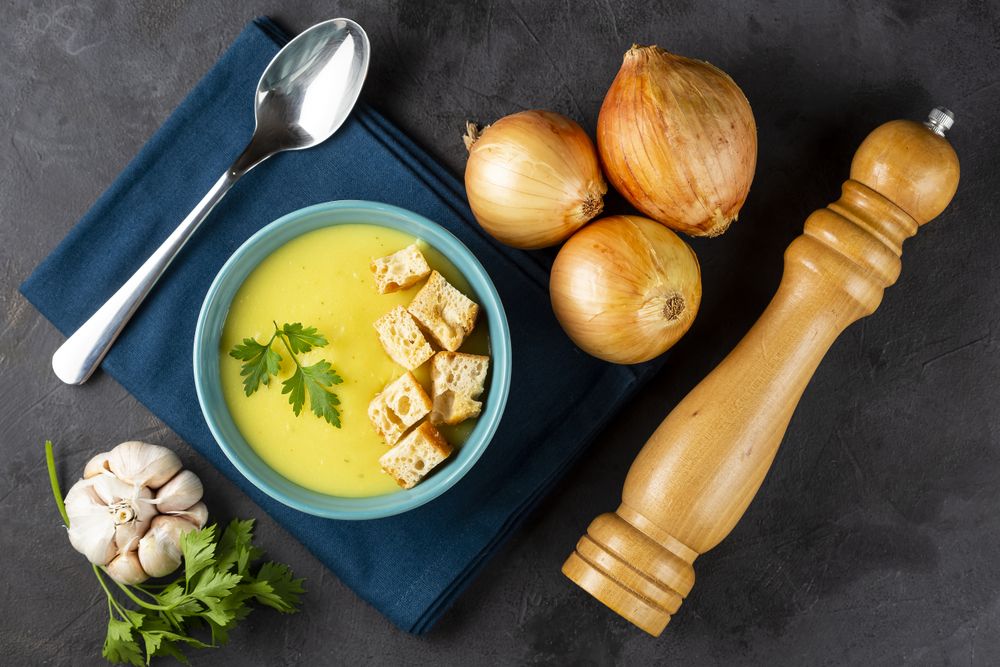 Bowl with onion soup and croutons on the table.