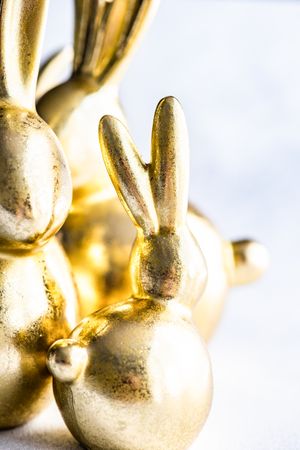 Easter holiday card concept with close up of golden rabbit figurines