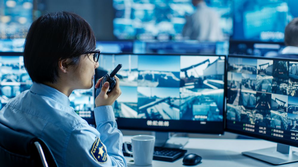In the Security Control Room Officer Monitors Multiple Screens for Suspicious Activities, He Reports any Unauthorised Activities in His Walkie-Talkie
