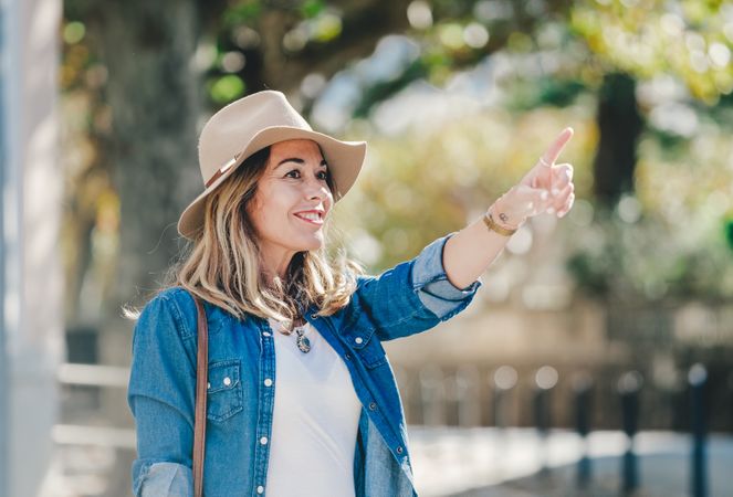 Tourist woman pointing and walking on the street