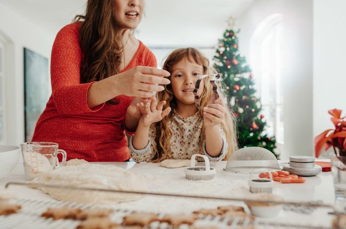 Mother and daughter preparing Christmas cookies in fun shapes