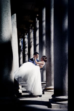 Newly weds having fun between columns