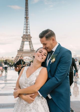 Happy newlyweds in wedding clothing cuddling