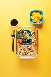 Plastic containers with healthy food and fork