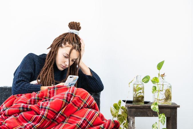 Woman with dreadlocks using a cellphone t home