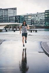 Muscular man in rain running in the rain