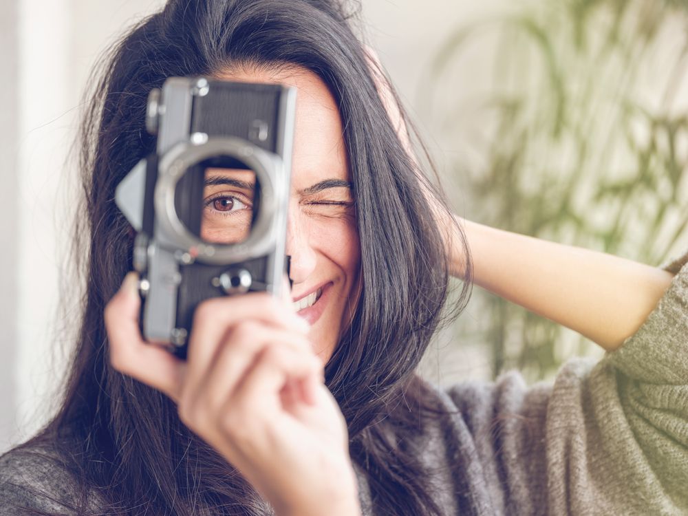 Winking woman with retro photo camera