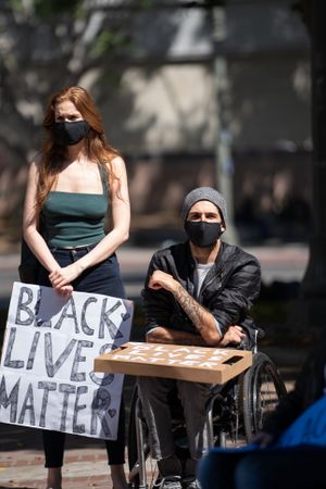 Los Angeles, CA, USA — June 16th, 2020: two people listening to speakers at protest rally