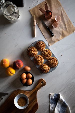Homemade muffins and cooking ingredients on table