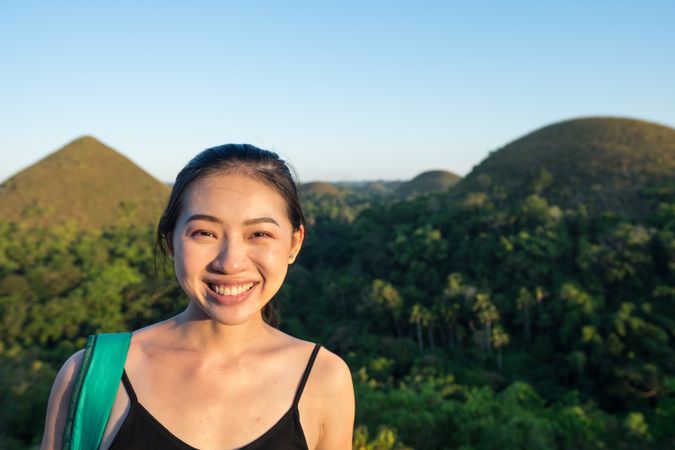 Happy woman standing on observation deck on hill