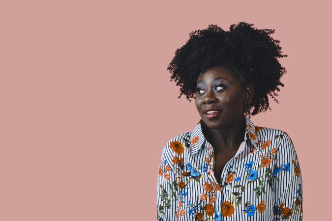 Studio shot of Black woman in floral print shirt looking to the side