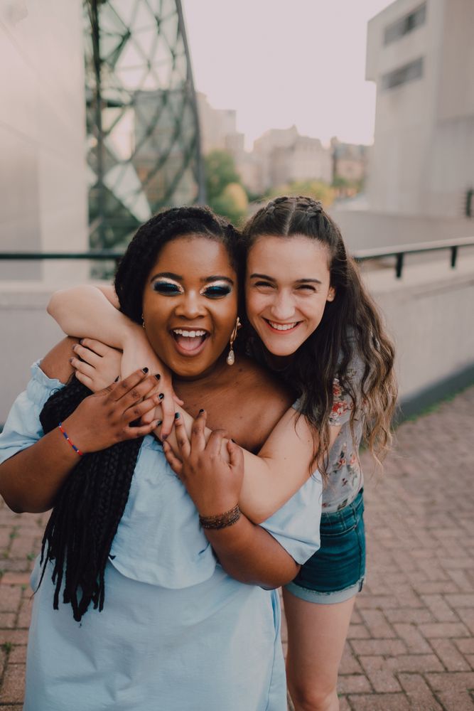 Multiethnic modern women embracing on street