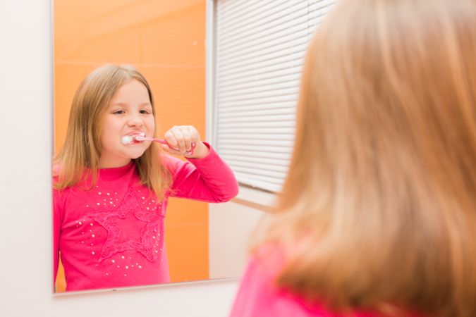 Cute girl brushing her teeth