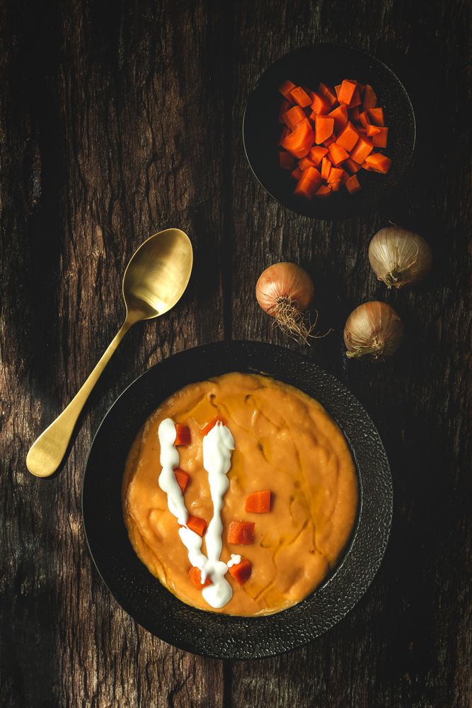 Orange cream soup and sliced carrot in bowls