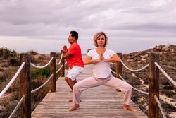 Adult couple meditating on wooden path