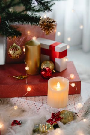Gift boxes and candle under Christmas tree