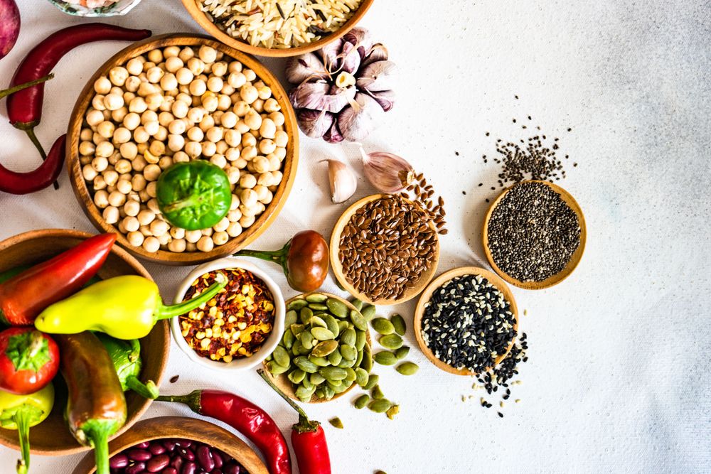 Top view of bowls of dried beans, aromatics and seeds for chilli