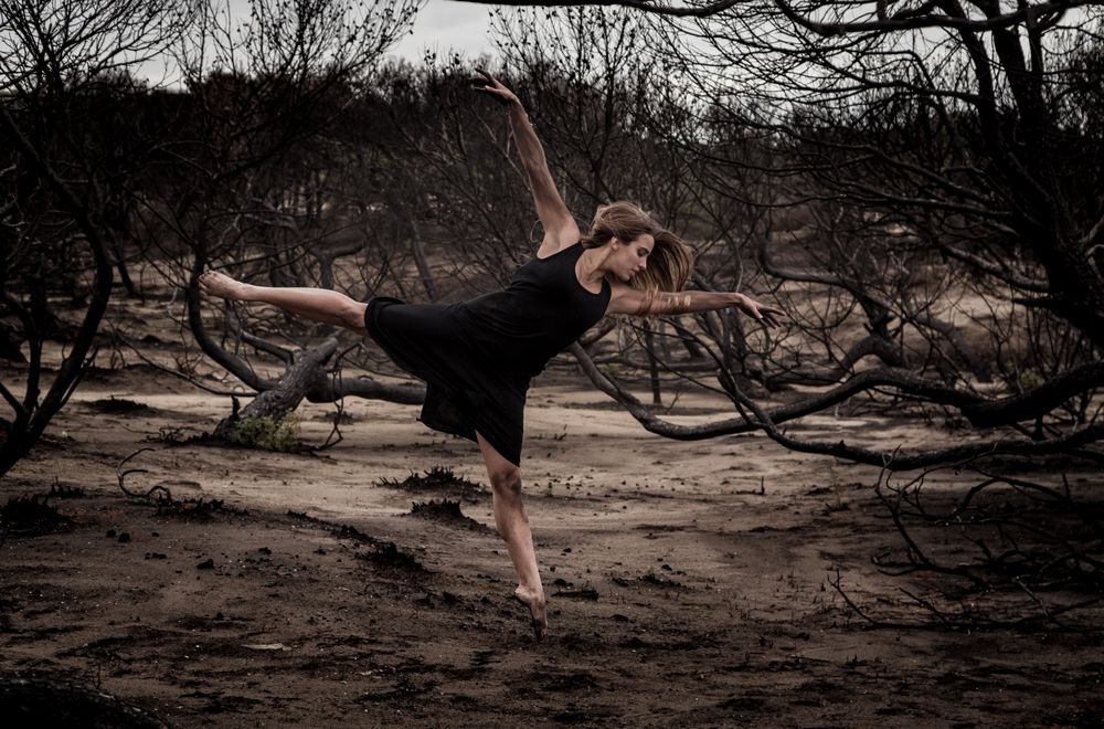 Woman dancing between dry trees
