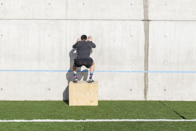 Man training on sports ground near wall