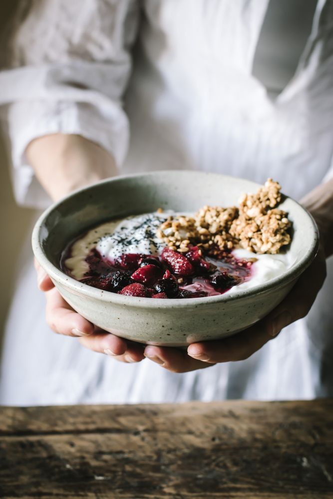 Faceless person with breakfast bowl with quinoa, rice and groats