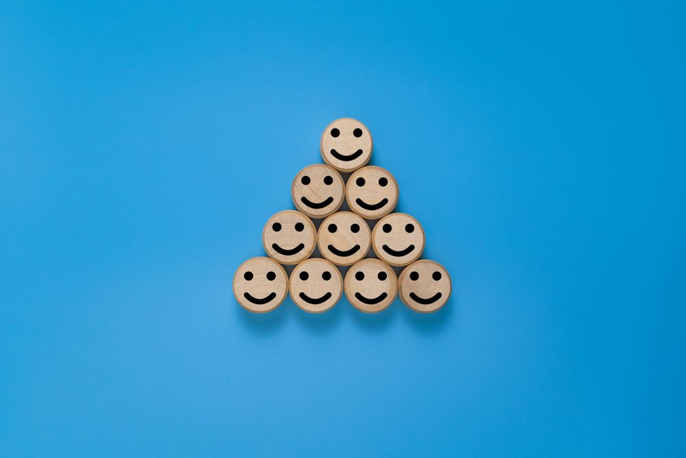 smile expression emoji on pyramid round wooden. isolated on blue background
