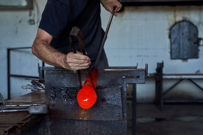 Crop man shaping liquid glass with jacks