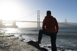 Tourist gazing at scenic bridge at peaceful bay