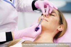Woman having the tip of her nose injected 5XeLM4