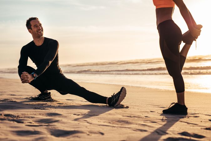 Two people exercising on the beach in morning