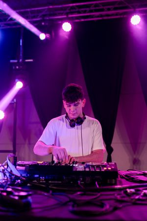 DJ working on stage electronic music in a club
