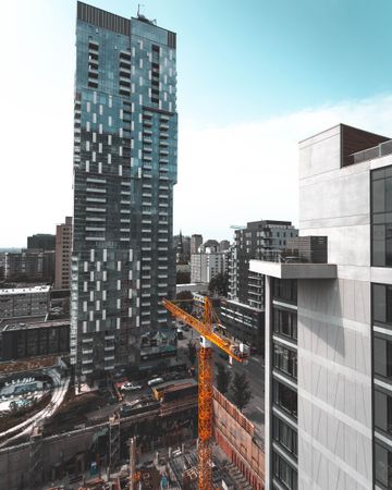 Yellow crane near high-rise building in city
