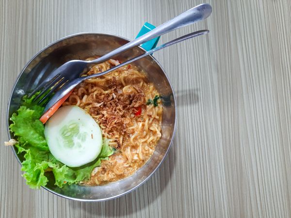 Top view of delicious Mie Goreng or fried noodles served in a stainless bowl.