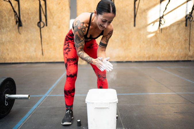 Woman applying magnesium powder to her hands for weightlifting