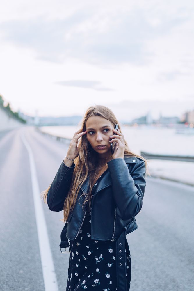 Long haired stylish woman speaking on smartphone