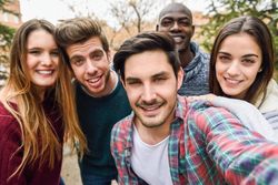 Smiling group of men and women looking at camera and posing for picture