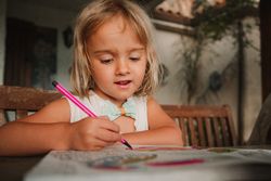 Girl coloring pictures at home