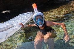 Woman in snorkeling mask swimming in sea