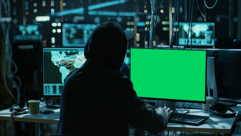 Hacker is Working With his Computer with Green Screen Mock-up Display Infect Servers and Infrastructure with Malware.