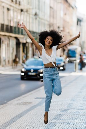 Black female jumping on urban background