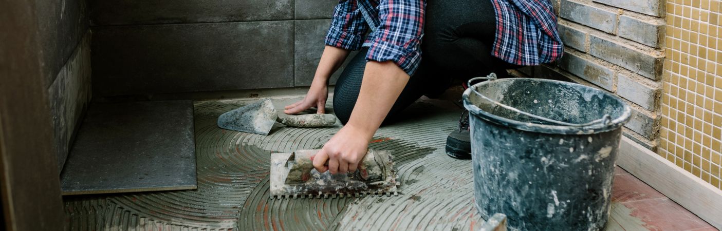 Female mason laying tiles on a terrace