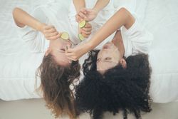 Women in bathrobe doing facial treatment with mask sheet