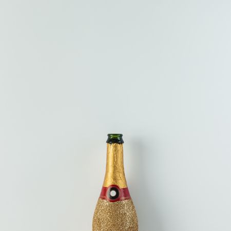 Golden champagne party bottle on light  background